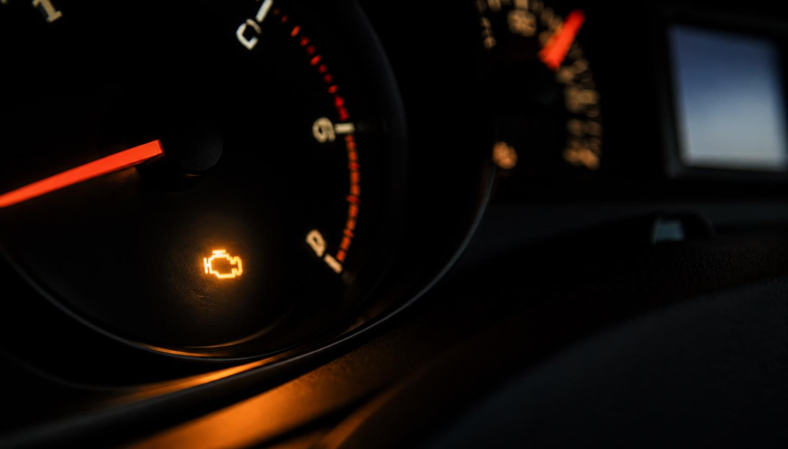 Amber engine warning light illuminated on a car dashboard
